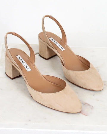 Pair of beige high-heeled shoes with 'Manolo Blahnik' label on a white background