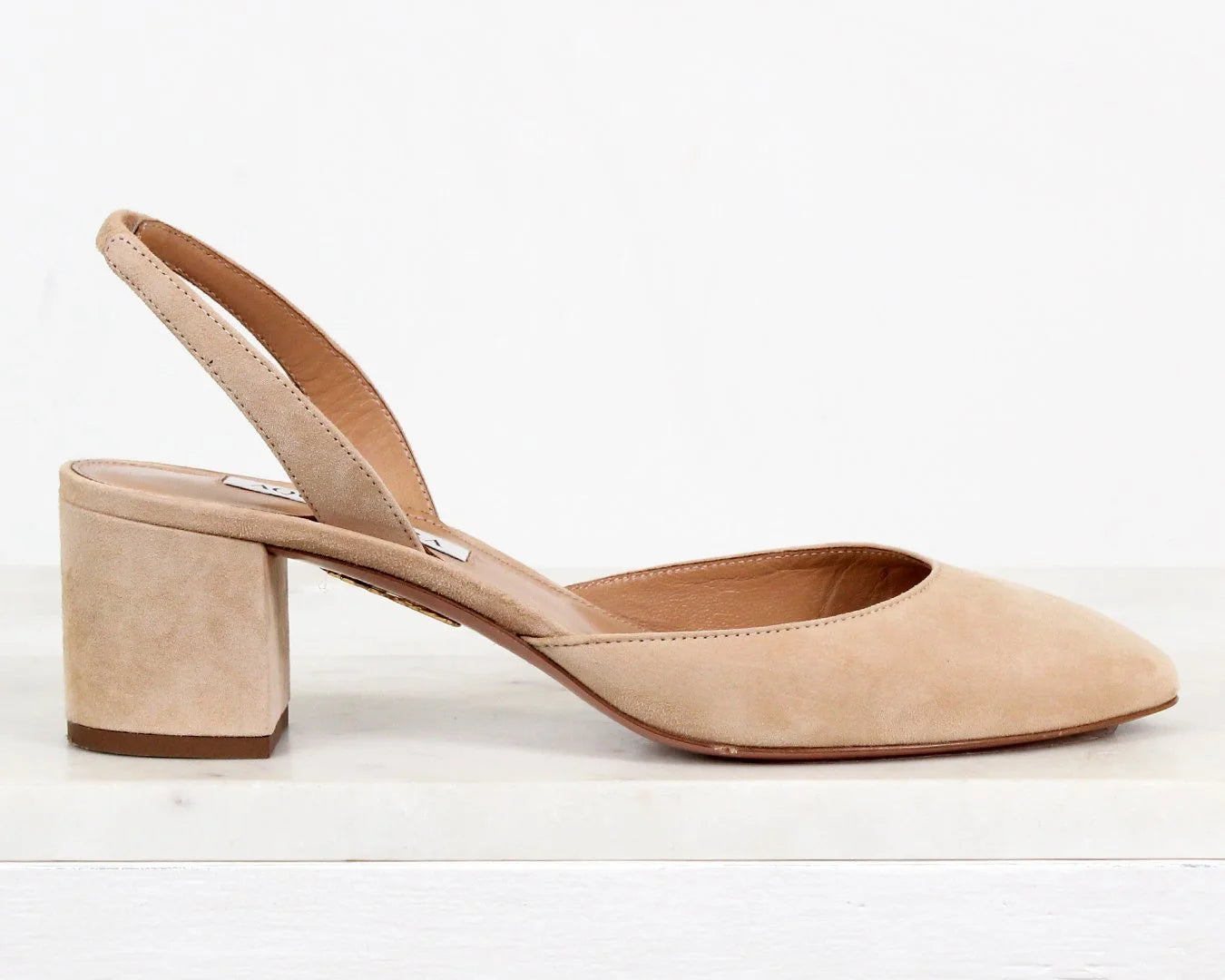 Beige suede slingback shoe on a white background
