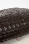 Close-up of a brown woven leather oversized tote on a light background