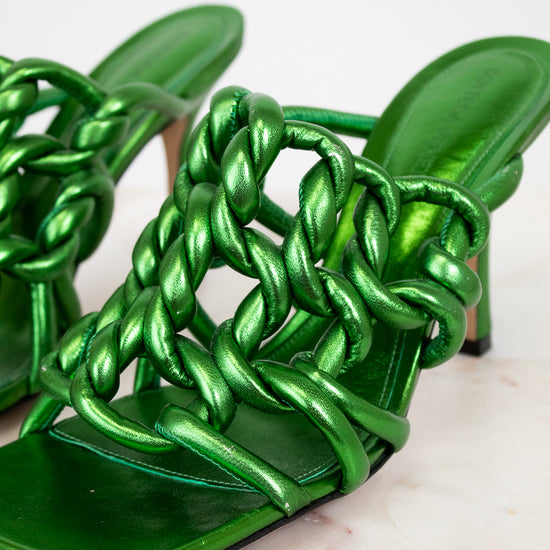 Green metallic sandals with braided design on a light background