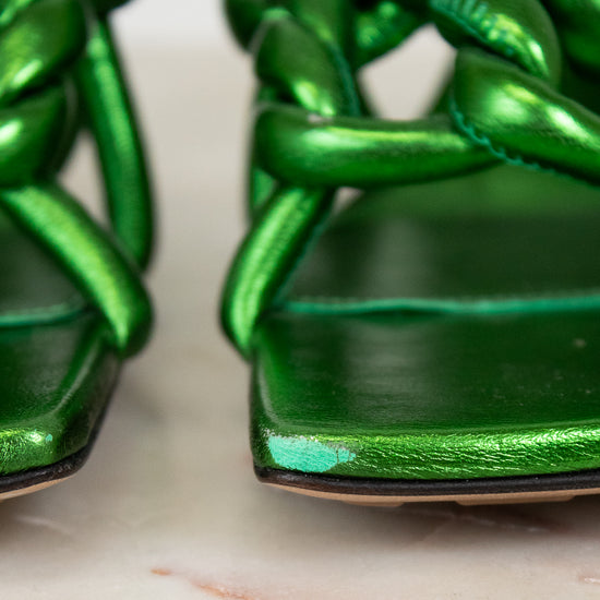 Close-up of green woven sandals on a marble surface