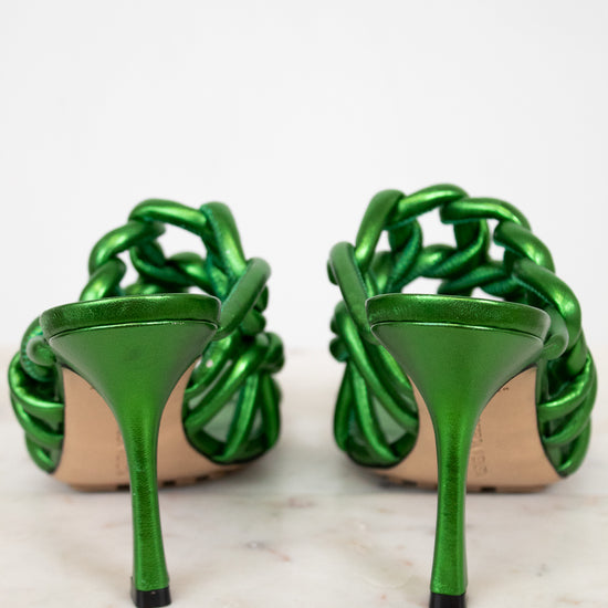 Pair of green high-heeled shoes on a white background