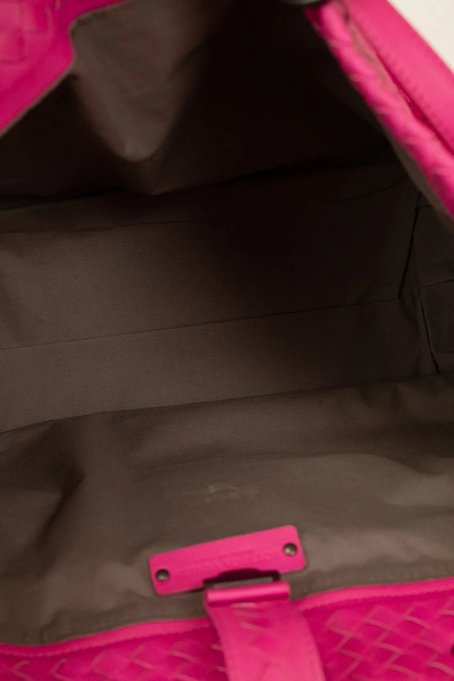 Close-up of a pink and black bag with a visible brand logo.