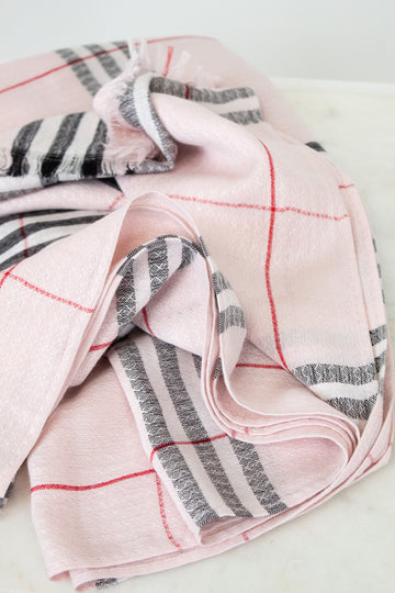 Folded pink and gray checkered fabric on a light background
