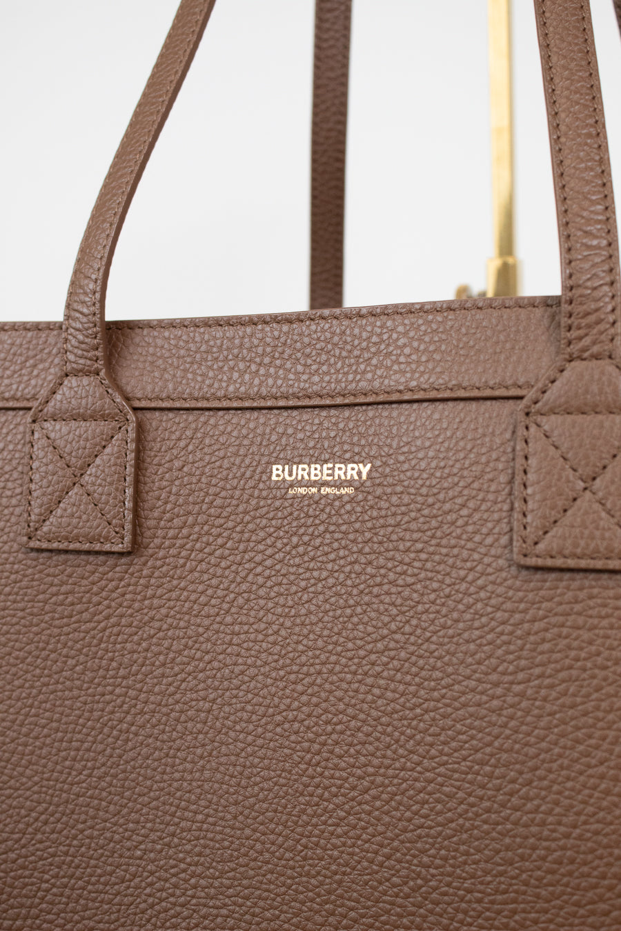 Brown Burberry handbag with visible logo on a light gray background