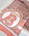 Close-up of a pink and white patterned fabric with a prominent 'B' logo.