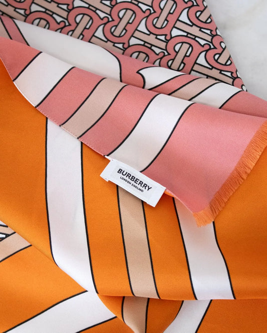 Burberry scarf with colorful stripes and a visible tag on a patterned background