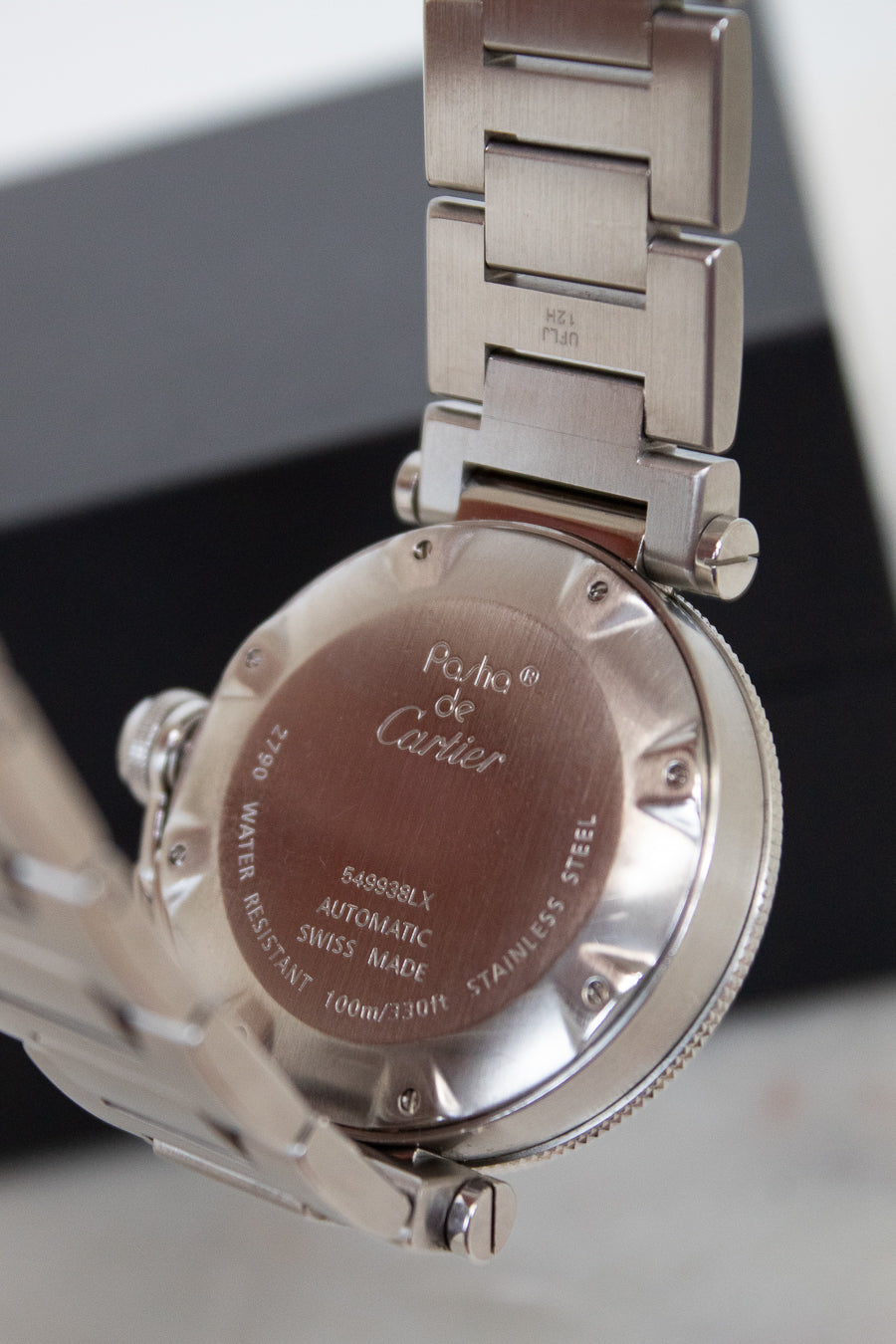 Close-up of a Cartier watch back cover with metal band