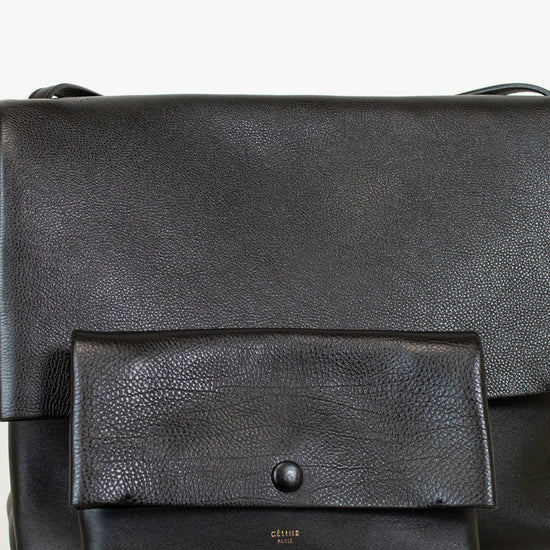 Black leather bag with a smaller pouch on a light background