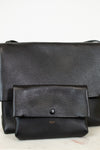 Black leather bag with a smaller pouch on a light background