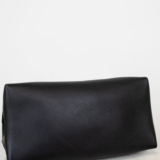 Black leather base of bag on a light marble surface