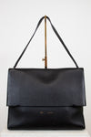 Black leather handbag with a strap on a white background