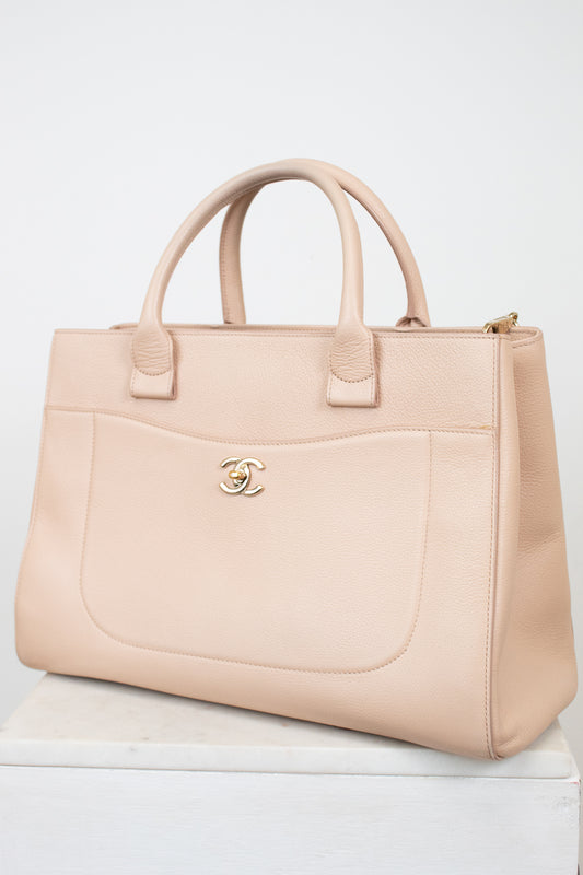 Beige handbag with Chanel logo on a white background