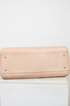 Beige handbag on a white surface with a white background
