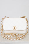 White quilted handbag with gold chain strap on a light gray background
