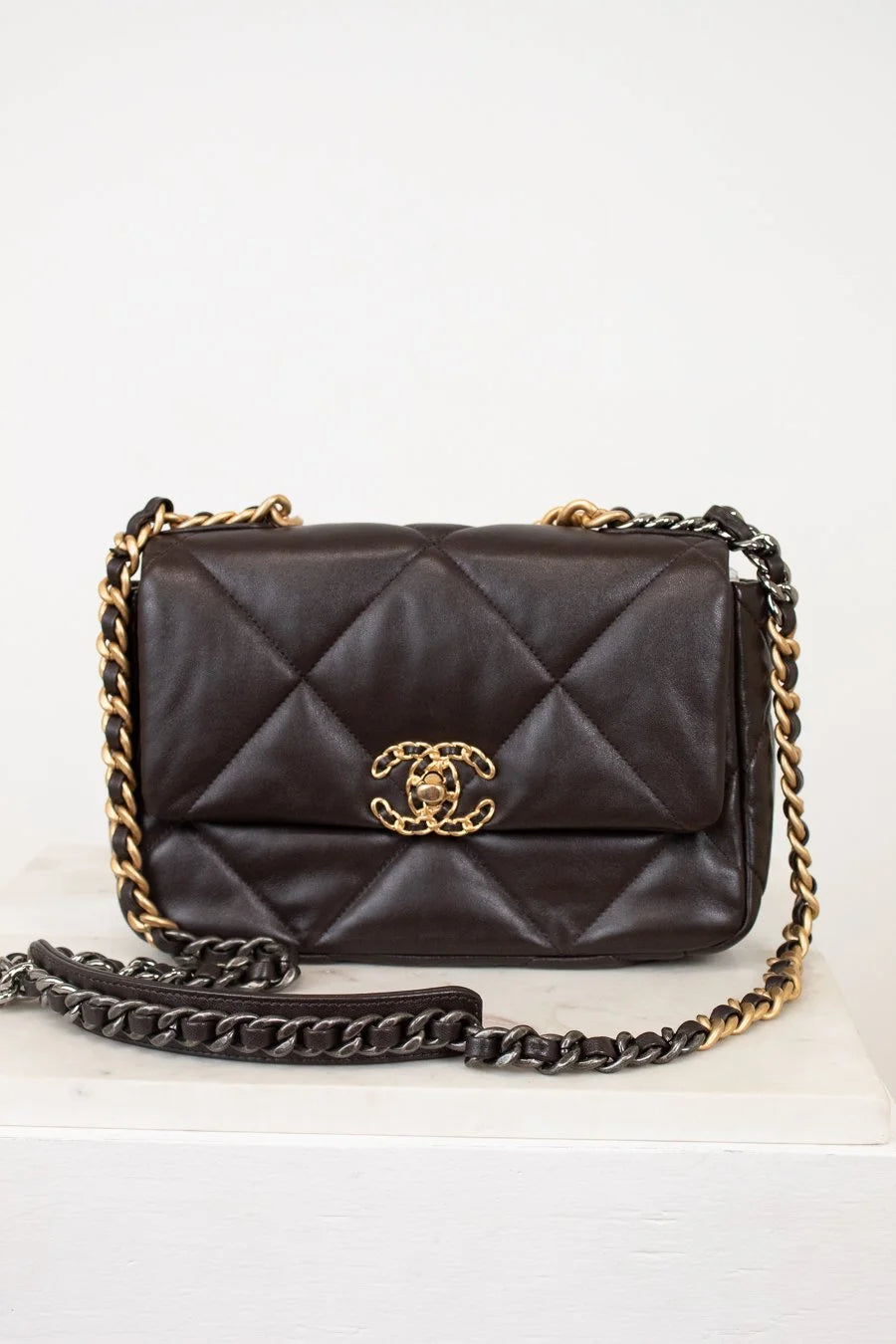 Dark Brown quilted handbag with gold chain strap on a white background