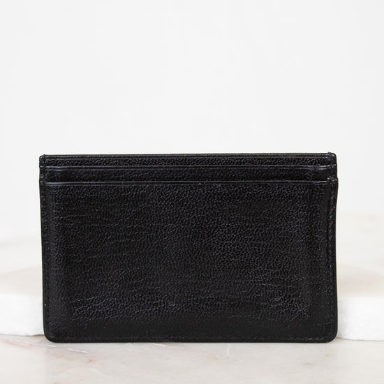 Black leather wallet on a white marble surface