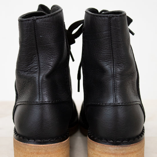 Black leather ankle boots with wooden soles on a white background