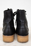 Black leather ankle boots with wooden soles on a white background