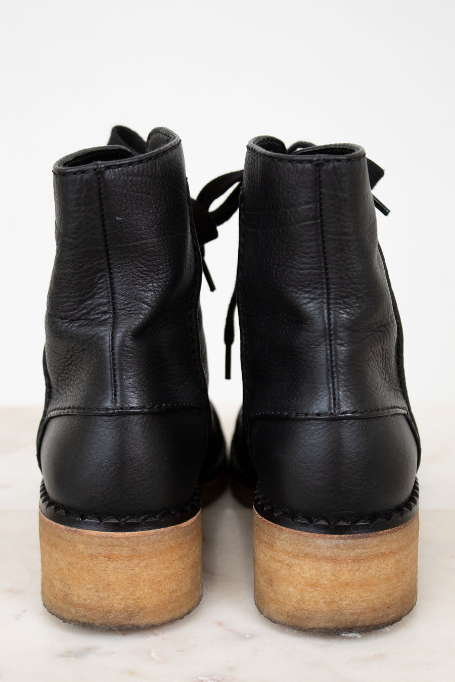Black leather ankle boots with wooden soles on a white background