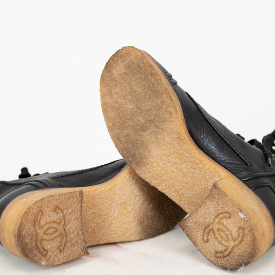 Black boots with tan soles on a white background