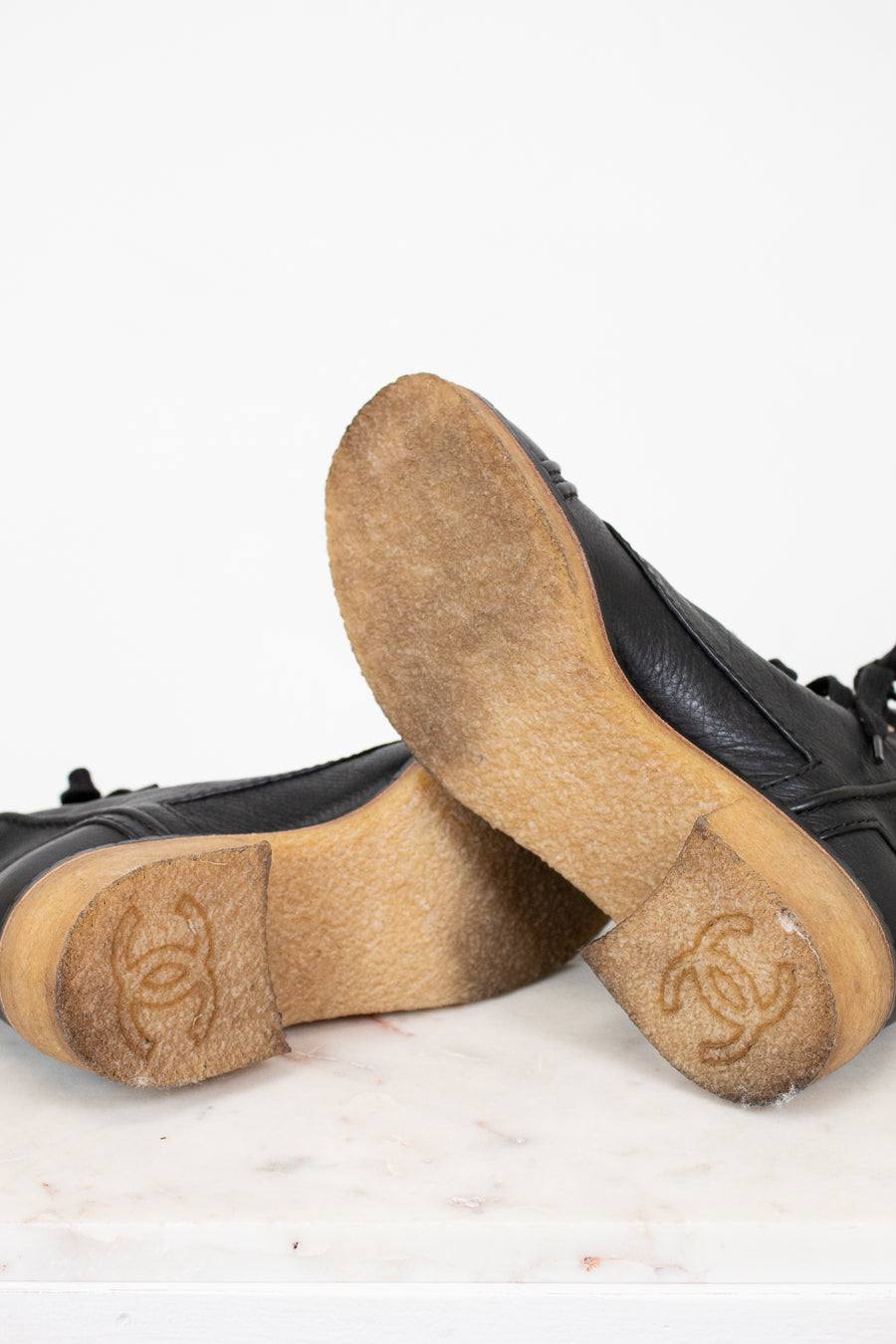 Black boots with tan soles on a white background