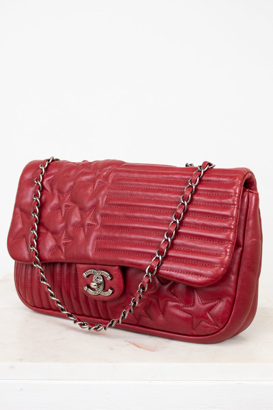 Red Chanel quilted handbag on white background
