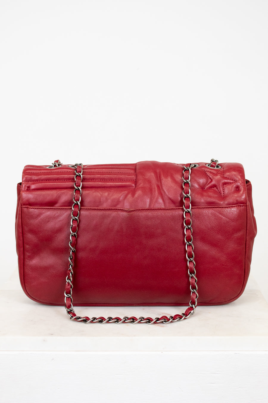 Red leather handbag with a chain strap on a white background