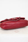 Red leather handbag with a chain detail on a light background