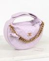 Lavender handbag with gold chain and Chanel logo on a white background