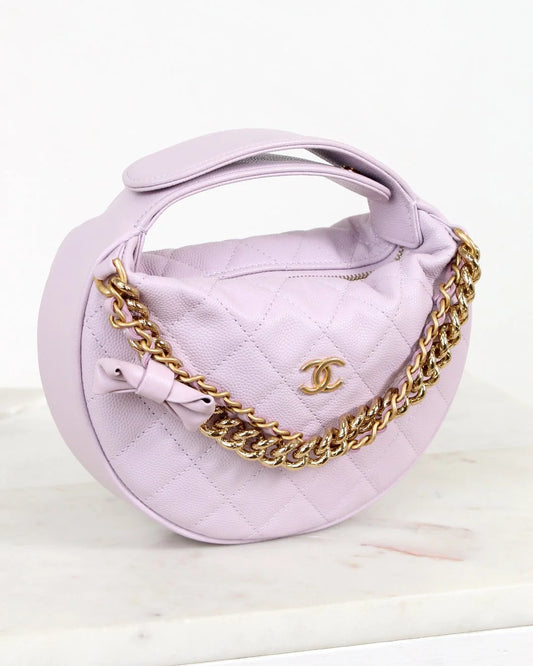 Lavender handbag with gold chain and Chanel logo on a white background