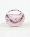 Lavender handbag with gold chain and Chanel logo on a white background