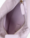 Close-up of interior of a light purple handbag with a gold zipper.