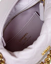 Close-up of interior of a Chanel handbag with gold hardware and visible branding.