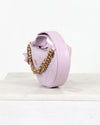 Lilac Crescent shaped bag with gold chain on a white surface