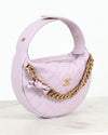 Lilac handbag with gold chain and bow detail on a white background