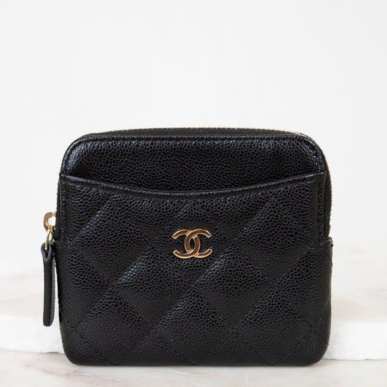 Black quilted wallet with gold logo on a white background