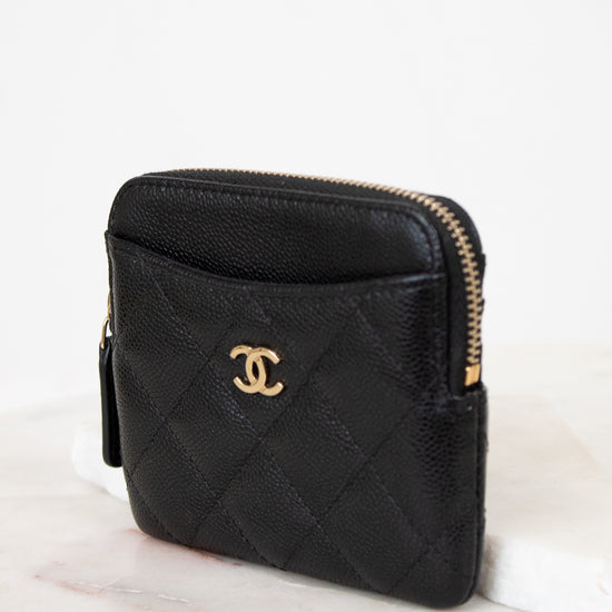 Black quilted wallet with gold logo on a white background