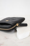 Black quilted wallet with gold logo on a white background