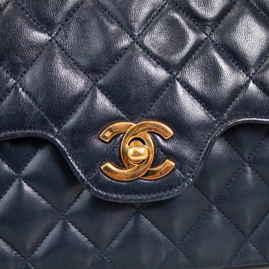 Navy quilted leather handbag with gold Chanel logo on a light background