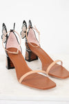 Pair of high-heeled sandals with butterfly accents on a white background