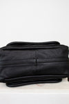 Black leather purse on a light gray background