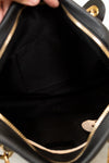 Close-up of a black handbag with gold accents
