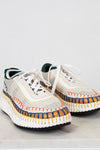 Pair of white sneakers with colorful accents on a light gray background