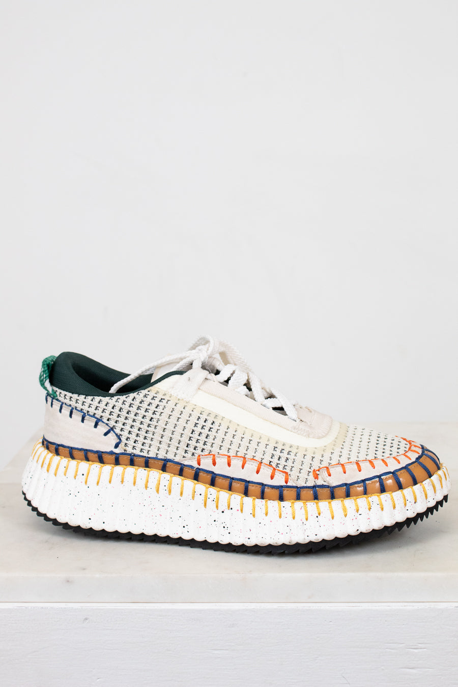 White sneaker with colorful sole on a white background