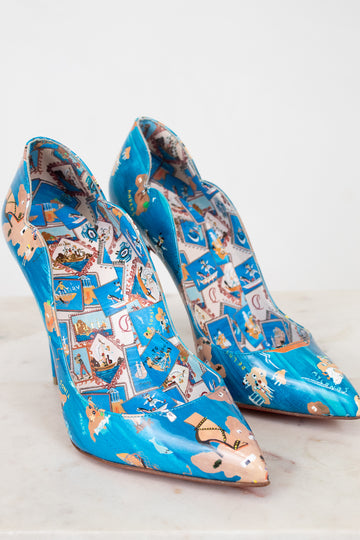 Pair of blue high-heeled shoes with decorative pattern on a white background