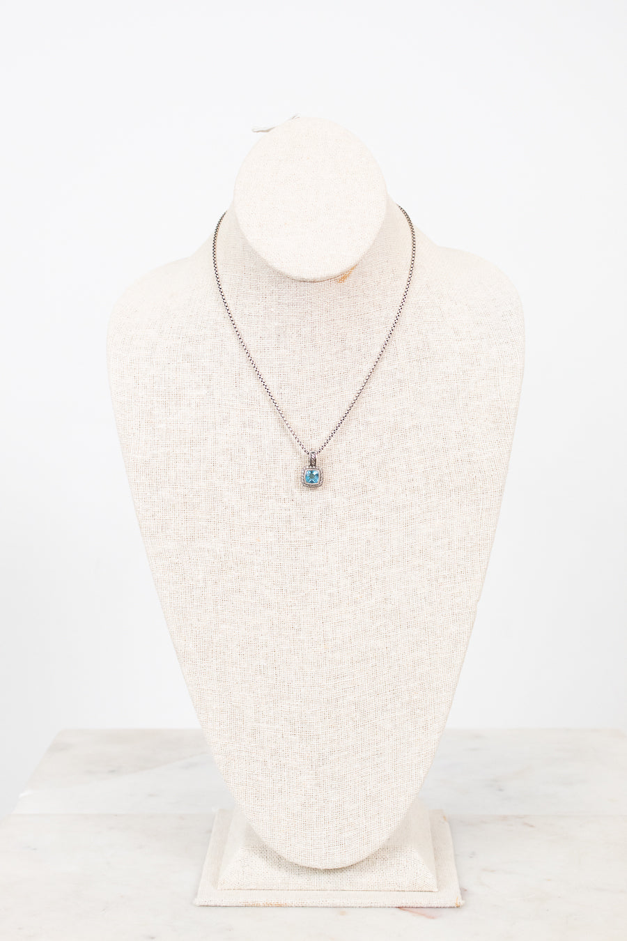 Necklace with a pendant on a mannequin bust against a white background