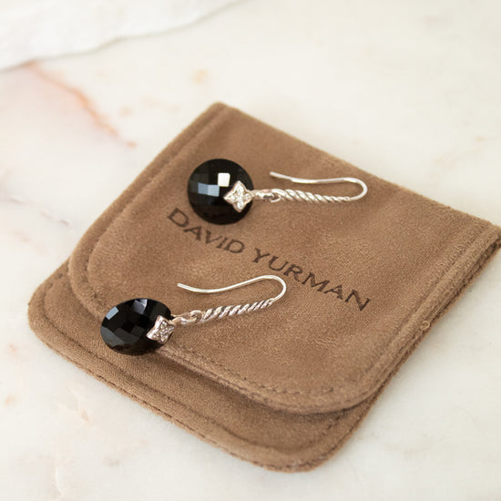 David Yurman earrings on a brown jewelry pouch with a marble background