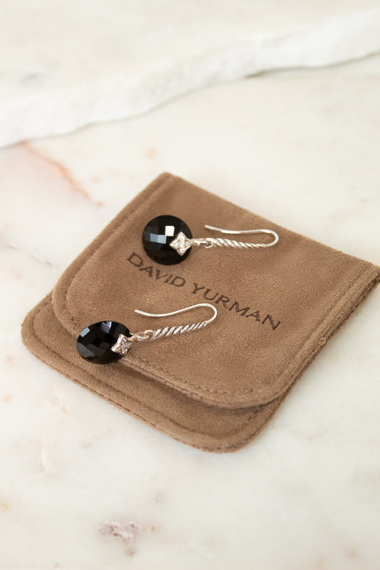 David Yurman earrings on a brown jewelry pouch with a marble background