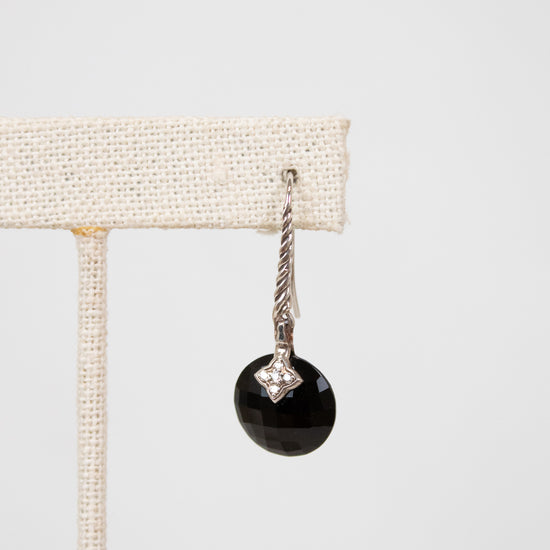 Black faceted bead earring with silver hook on a white background